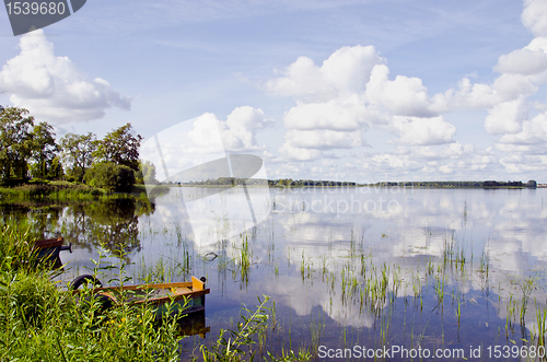 Image of Summer lake landscape boats clouds reflections 