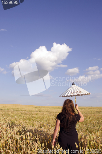 Image of Young woman walking in the field of wheat.