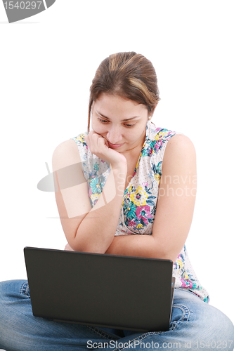 Image of Beautiful young woman sitting on floor with a laptop, isolated o