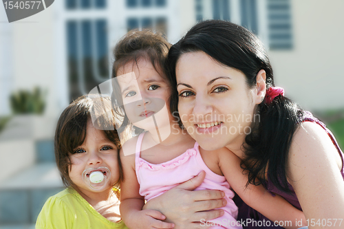 Image of Mother and Daughters portrait outdoors in front of their home