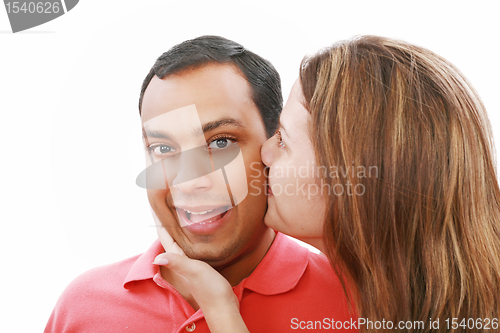 Image of Young woman kissing her surprised boyfriend, isolated on white