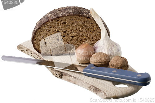 Image of brown bread on shelf with onion, garlic and walnut