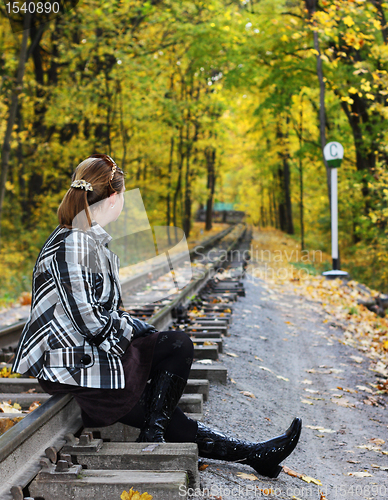 Image of Young women sits on a rails