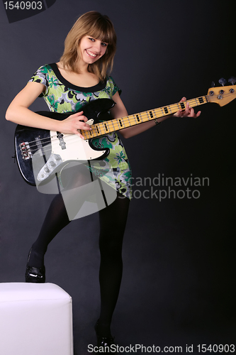 Image of Young beautiful girl with a guitar