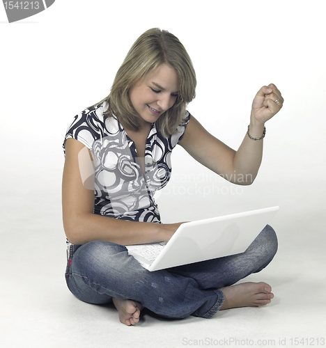 Image of successful computing girl sitting in light back