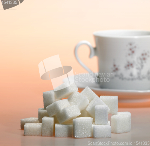 Image of lump sugar pile and coffee cup in warm light