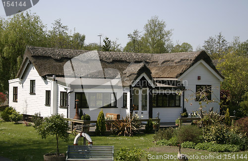 Image of thatched cottage with a conservatory