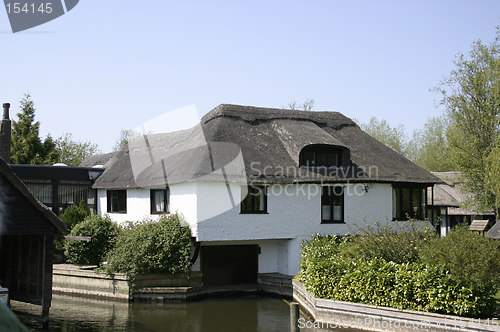 Image of thatched cottage next to the river