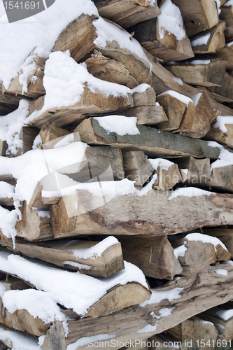 Image of stacked wood and snow