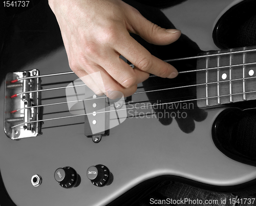 Image of hand on bass guitar