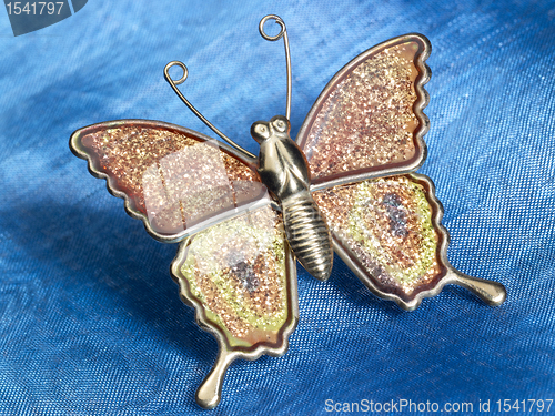 Image of butterfly trinket on blue fabrics