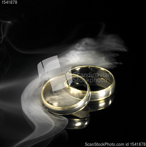Image of golden wedding rings and smoke