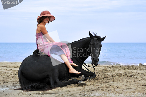 Image of woman and  horse on the beach