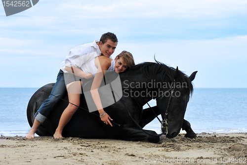 Image of couple and  horse on the beach