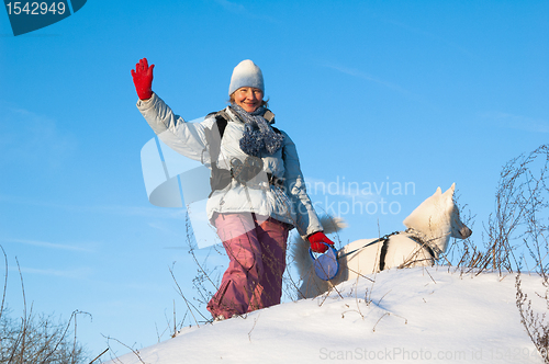 Image of The woman with a dog in winter on walk