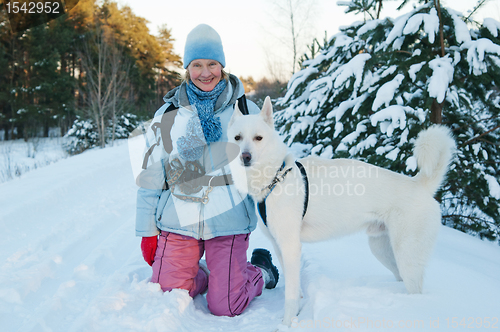 Image of The woman with a dog in winter on walk