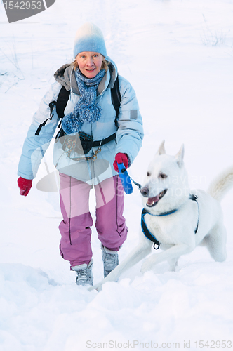 Image of The woman with a dog in winter on walk