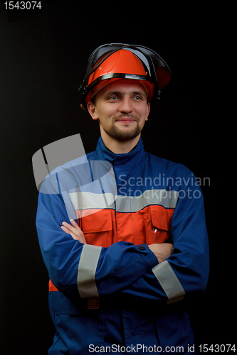 Image of The worker in overalls and a helmet