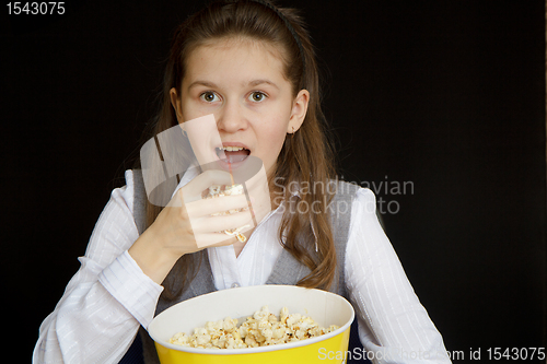 Image of surprised girl with popcorn on a black background