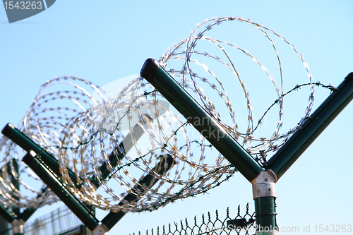 Image of barbed wire against blue sky 