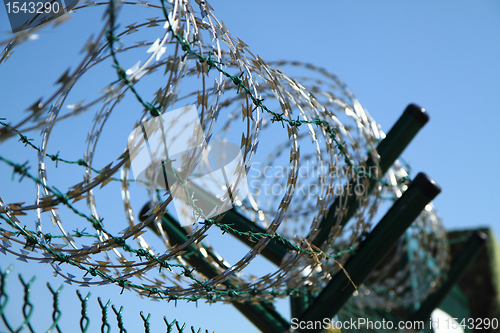 Image of barbed wire against blue sky 
