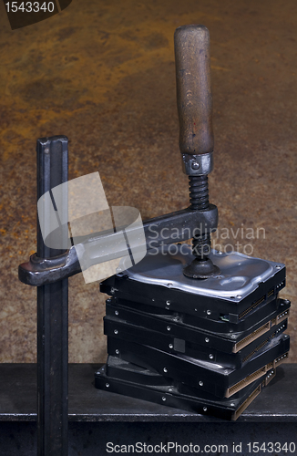 Image of clamp pressing on stack of hard drives