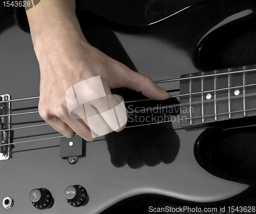 Image of hand on bass guitar