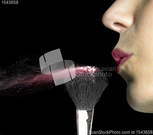 Image of red lips blowing make-up