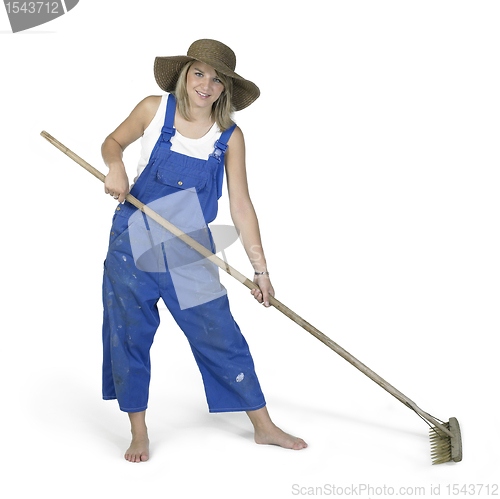 Image of cute girl dressed in workwear while raking