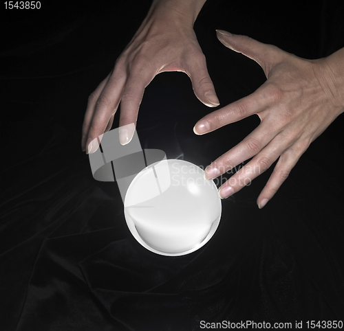 Image of crystal ball and hands around