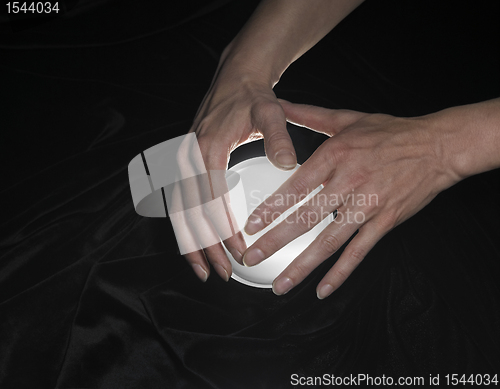 Image of crystal ball and hands around