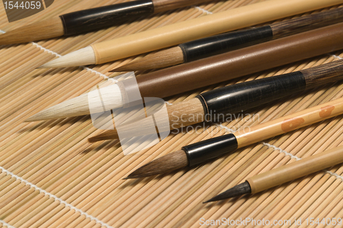 Image of chinese brushes on wooden mat detail