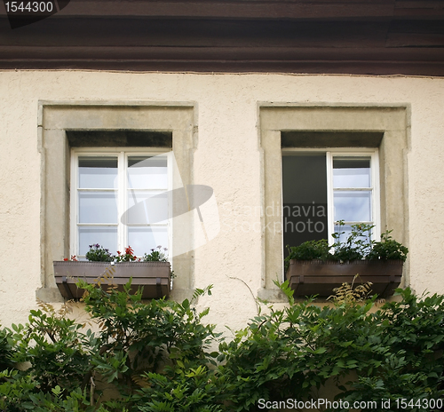 Image of house facade detail with two old windows