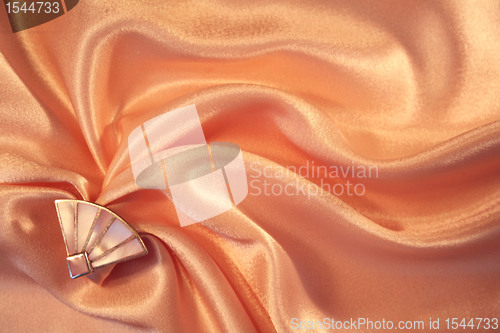 Image of Silver fan from nacre on the elegant pink silk 