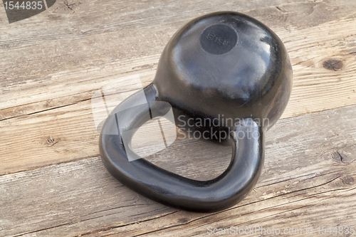 Image of black kettlebell on wood deck