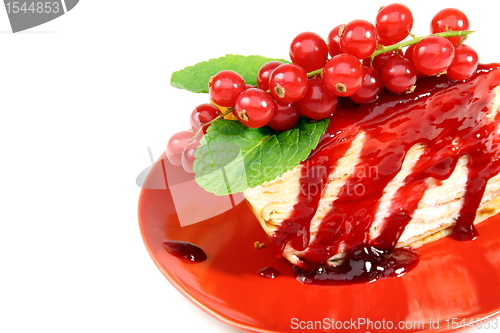 Image of Crepe cake with berry sauce closeup.