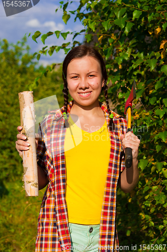 Image of young woman holding an axe and chock