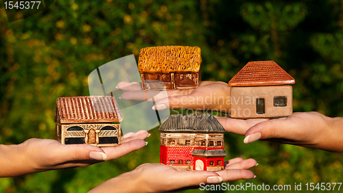Image of Four different houses in human hands
