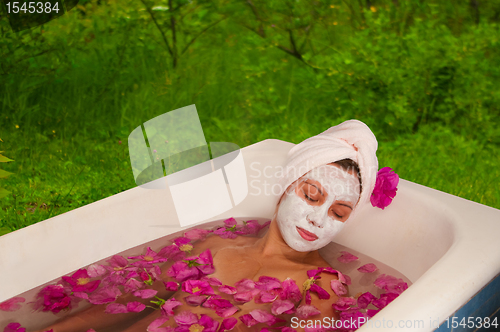 Image of beautiful woman enjoying floral bath