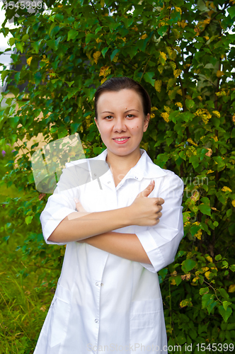 Image of cheerful smiling woman doctor outdoors