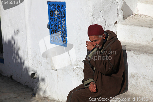 Image of The old man sitting on the stairs