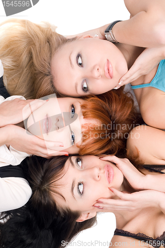 Image of Three young women touching their cheeks
