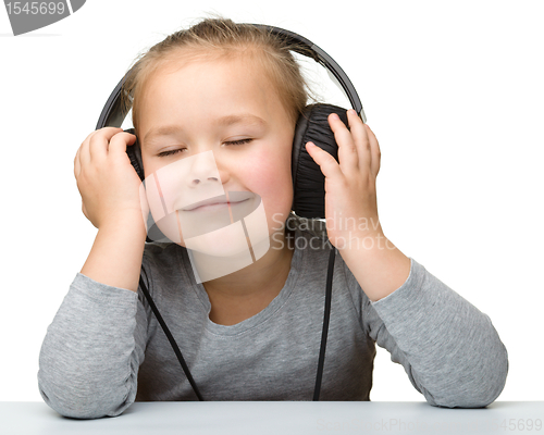 Image of Cute girl enjoying music using headphones