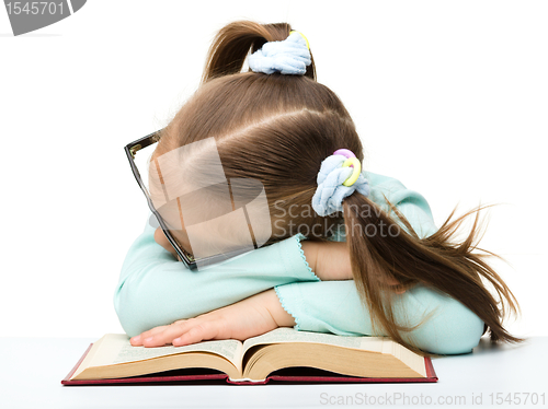 Image of Little girl is sleeping on a book