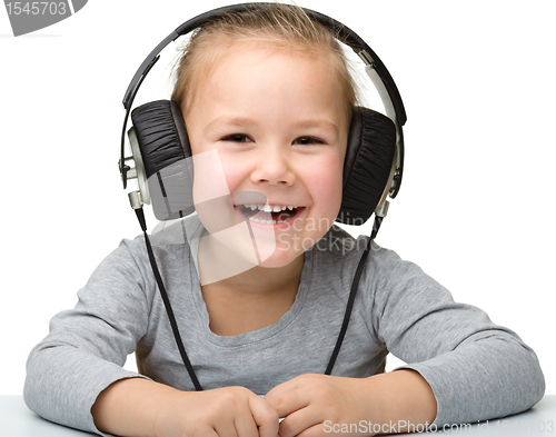 Image of Cute girl enjoying music using headphones