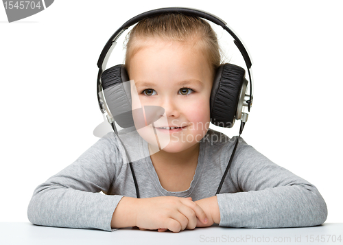 Image of Cute girl enjoying music using headphones