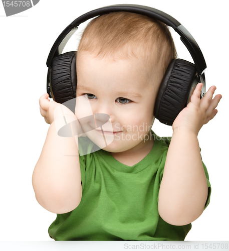 Image of Cute boy enjoying music using headphones
