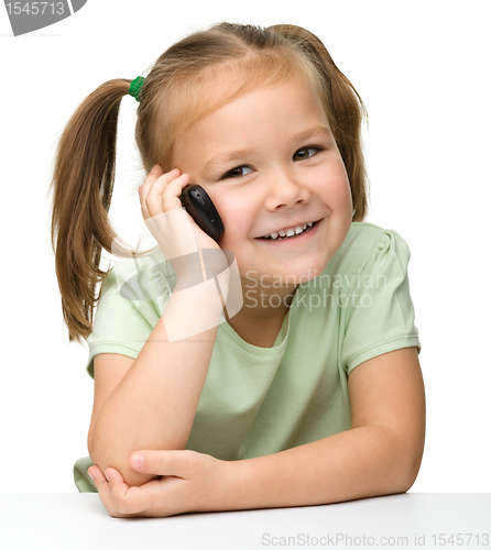Image of Cute little girl is talking on cell phone