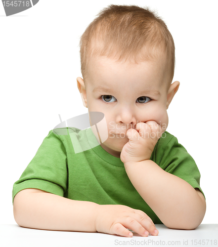 Image of Pensive little boy support his head with hands