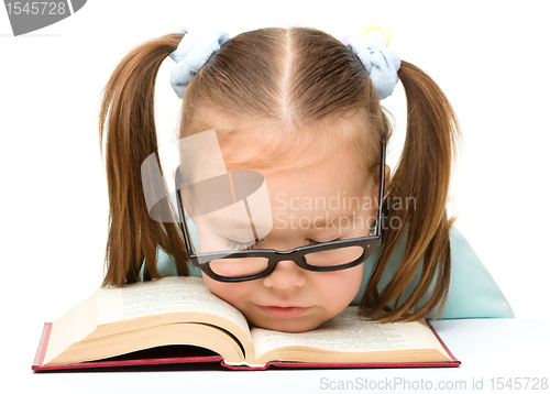 Image of Little girl is sleeping on a book